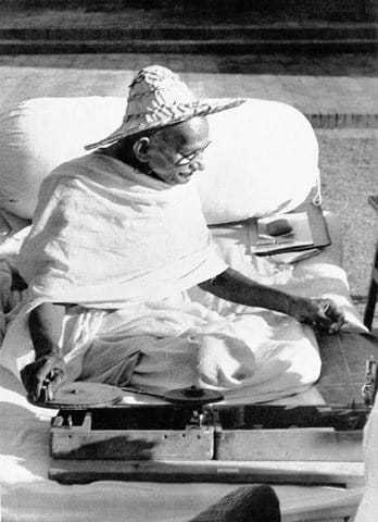 Mahatma Gandhi wearing a Noakhali hat whilst spinning at Birla House New Delhi India. November 1947.