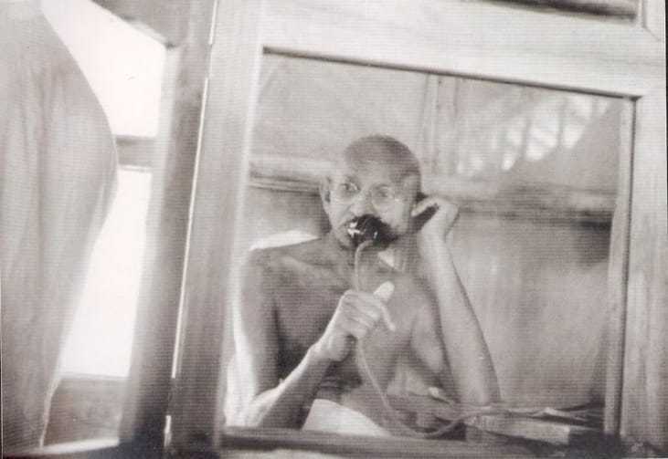 Mahatma Gandhi telephoning from the office hut at Satyagraha Ashram, Sevagram,1938.