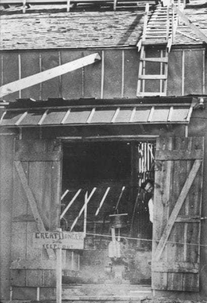 Tesla peaks out the door of the Colorado Springs laboratory, early summer 1899.