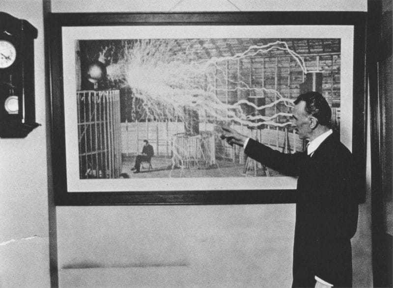 Tesla in 1916 pointing to a discharge in a photograph taken at Colorado Springs in 1899.