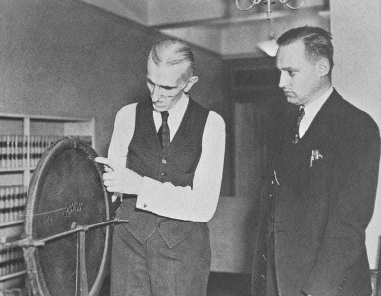 Photo two of three. Tesla and John T. Morris of the Westinghouse Electric & Manufacturing Company examine the alternator that had been discovered.