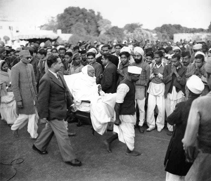 Mahatma Gandhi, is carried from his main house to the Garden area after breaking a five-day fast in New Delhi, India on January 21, 1948.