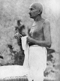 Gandhi cleaning his spectacles, Wardha. 1939.