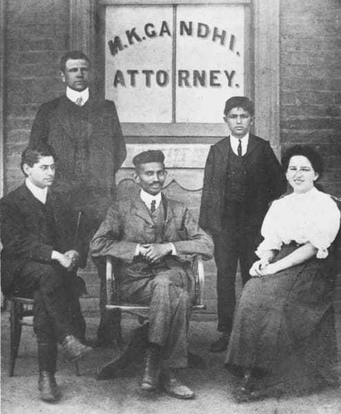 Mohandas Gandhi (center) sits with co-workers at his Johannesburg law office in 1902