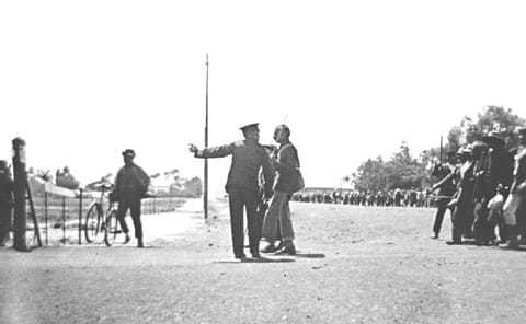 Policeman confronting Gandhi as he led the striking Indian, 1913